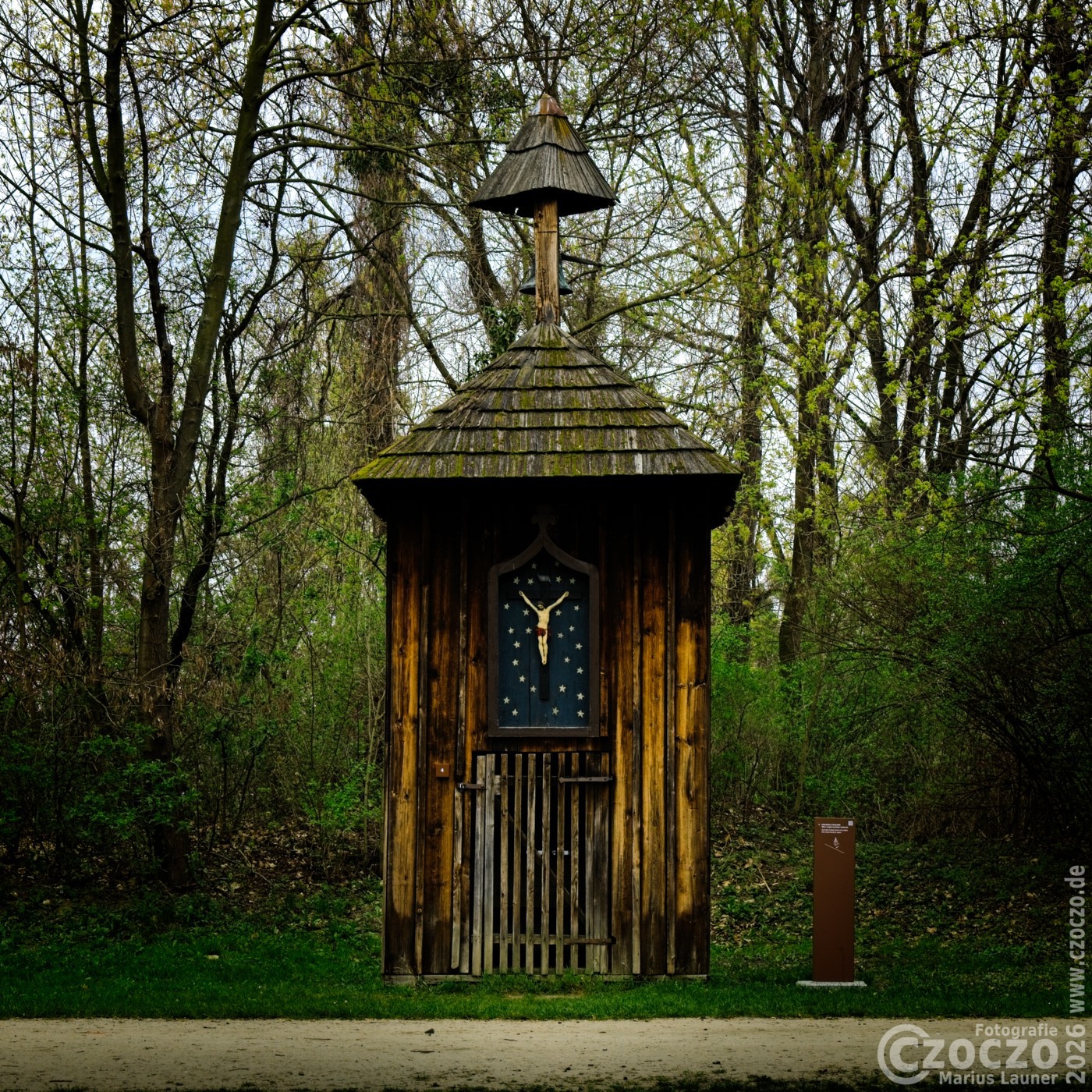 Historische hölzerne Wegkapelle im Freilichtmuseum Oppeln (Schlesien) mit Kruzifix vor Sternenhintergrund.